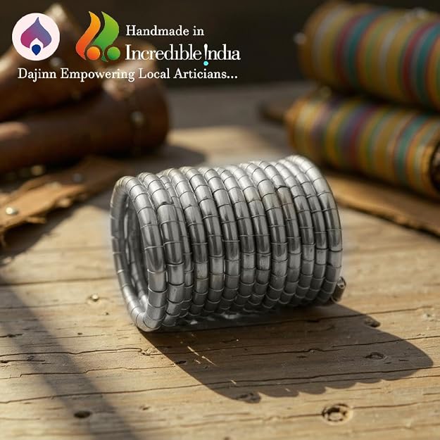 Set of traditional brass bangles in a sleek coil style with an antique finish, stacked on a wooden surface.
